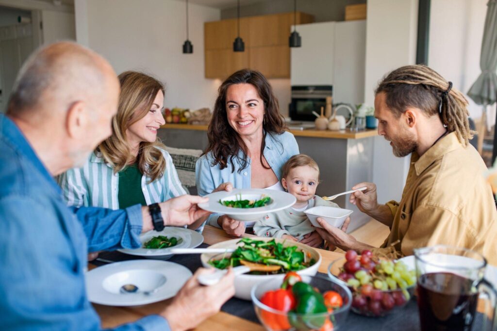 Happy family at the dining table at home eating healthy lunch.